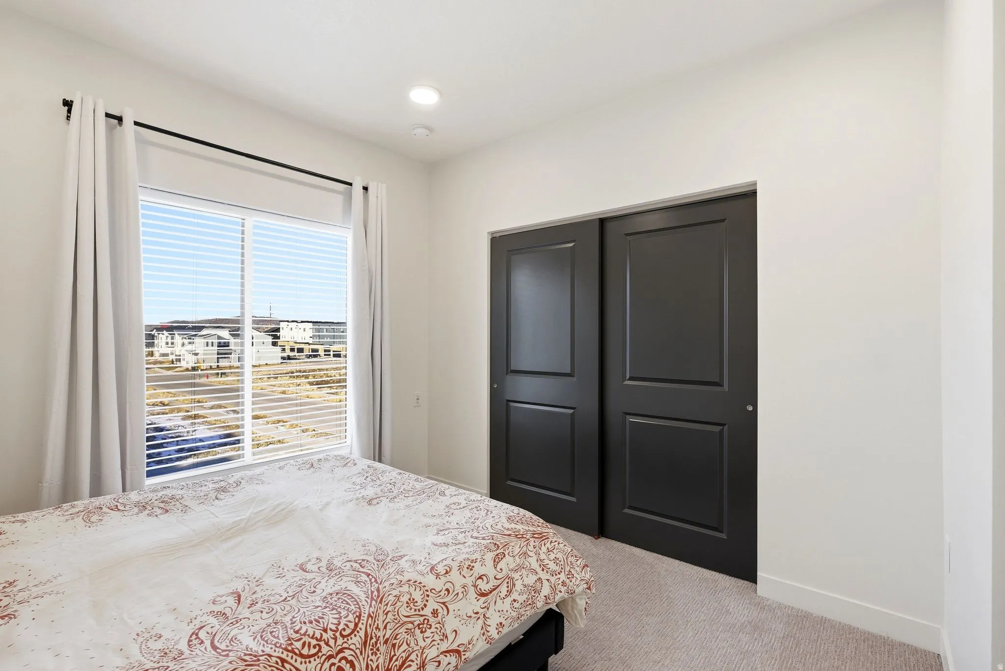 Bedroom with light carpet, a closet, and recessed lighting