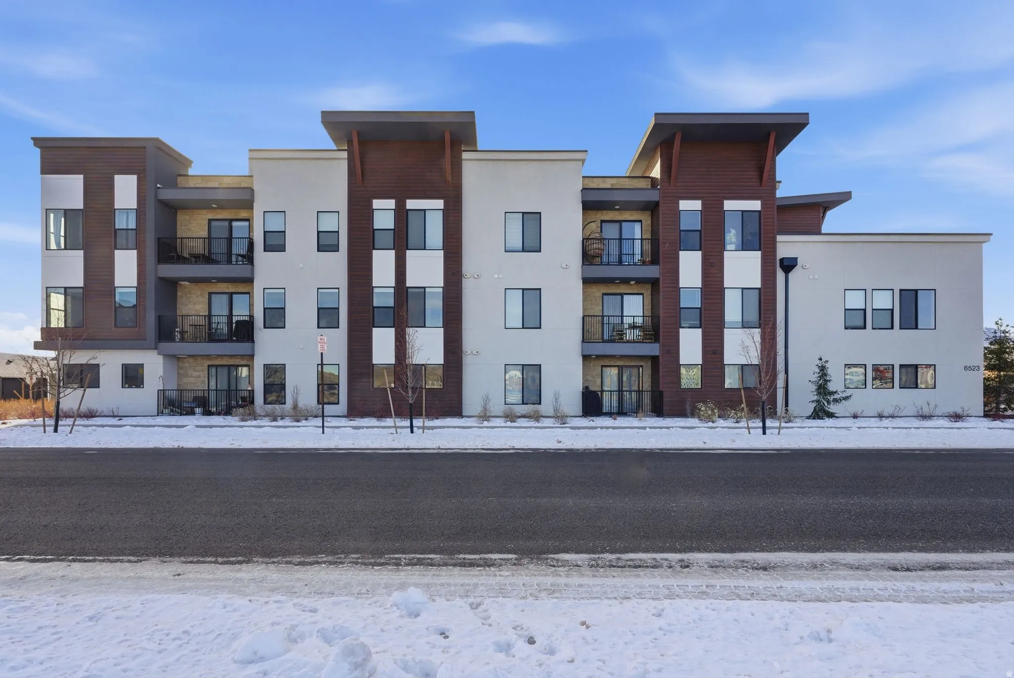 Snow covered building featuring a view of apartment building / complex