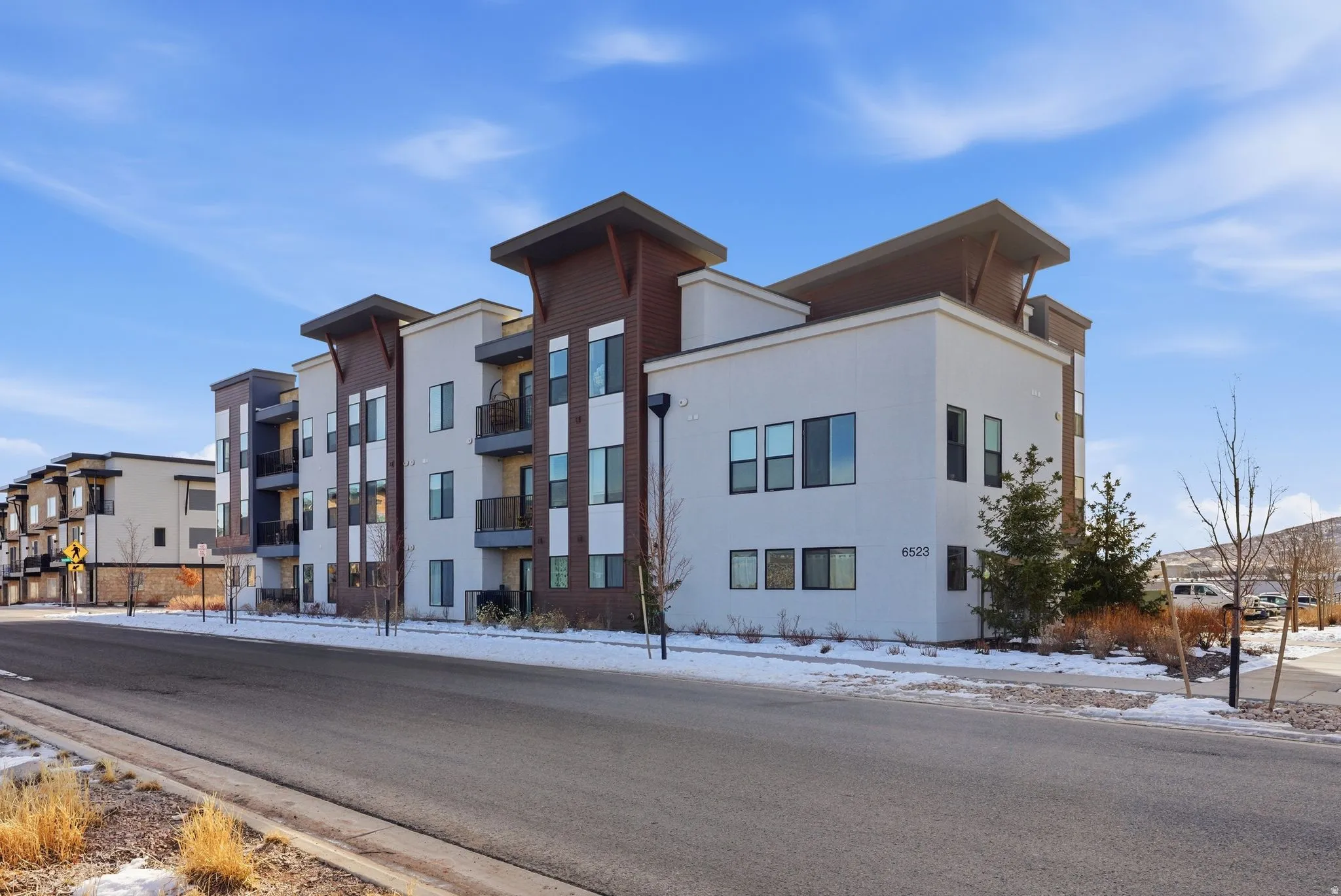 Snow covered property featuring a view of apartment building / complex