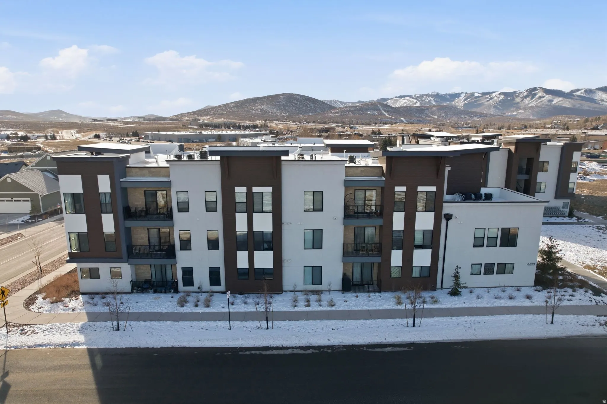 Snow covered property featuring a mountain view and a residential view