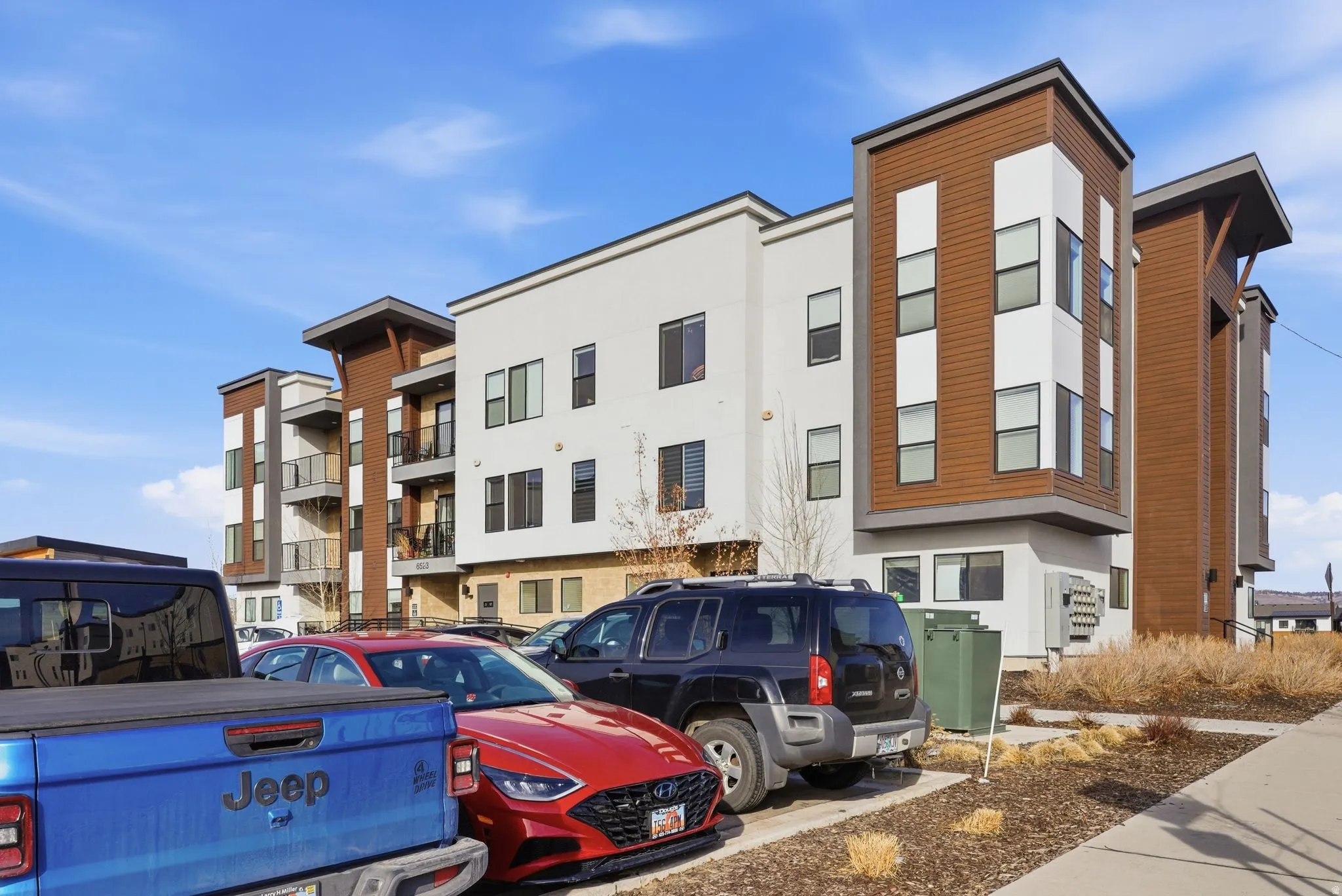 View of building exterior with uncovered parking