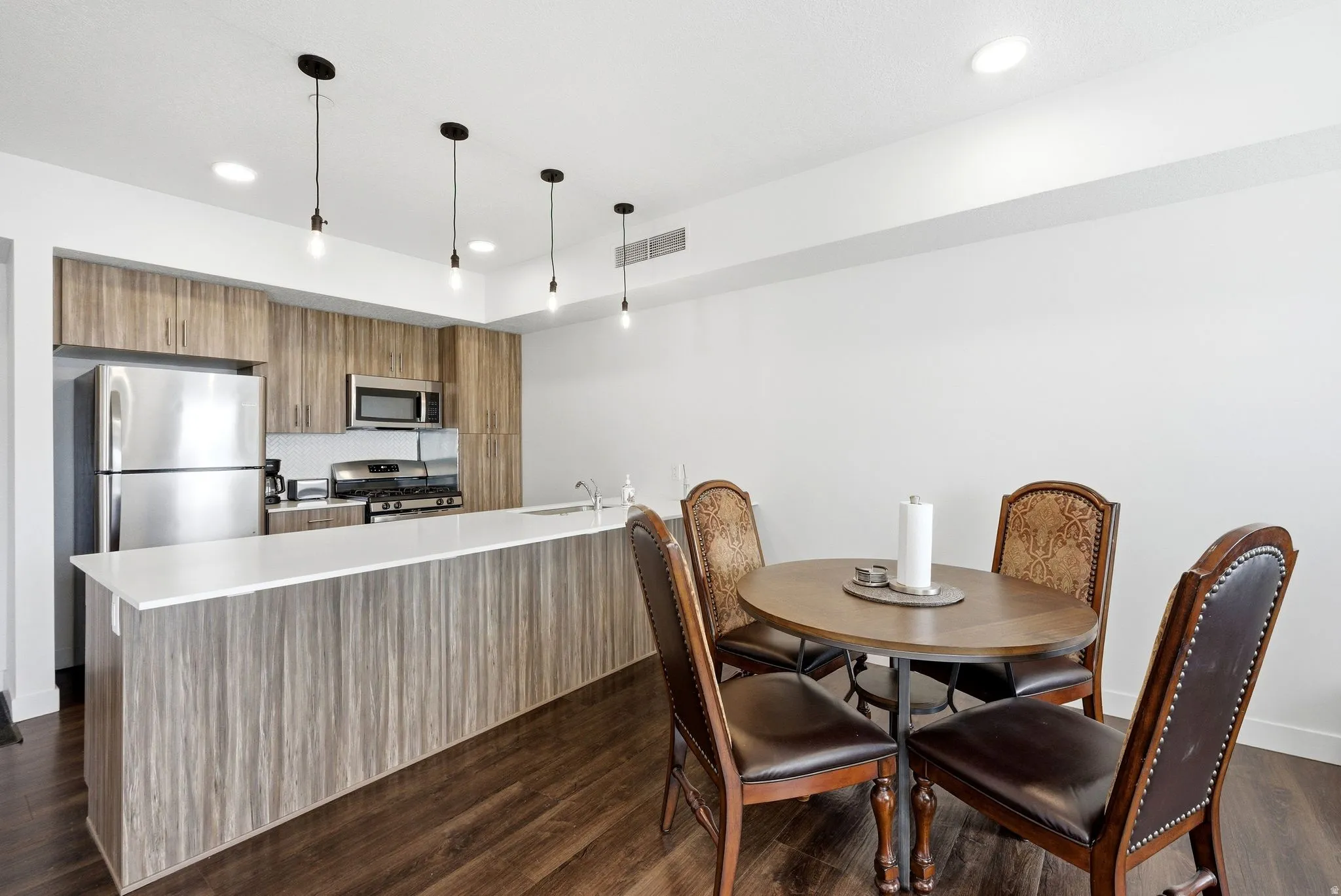 Dining space with dark wood-style flooring and recessed lighting