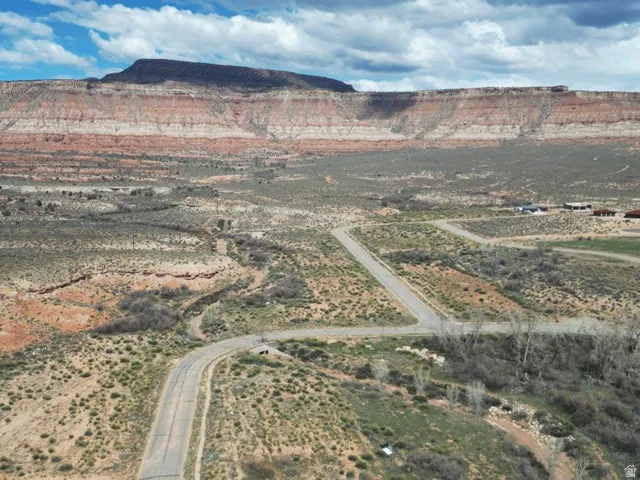 Aerial view of property and surrounding area featuring rural landscape and a mountain backdrop