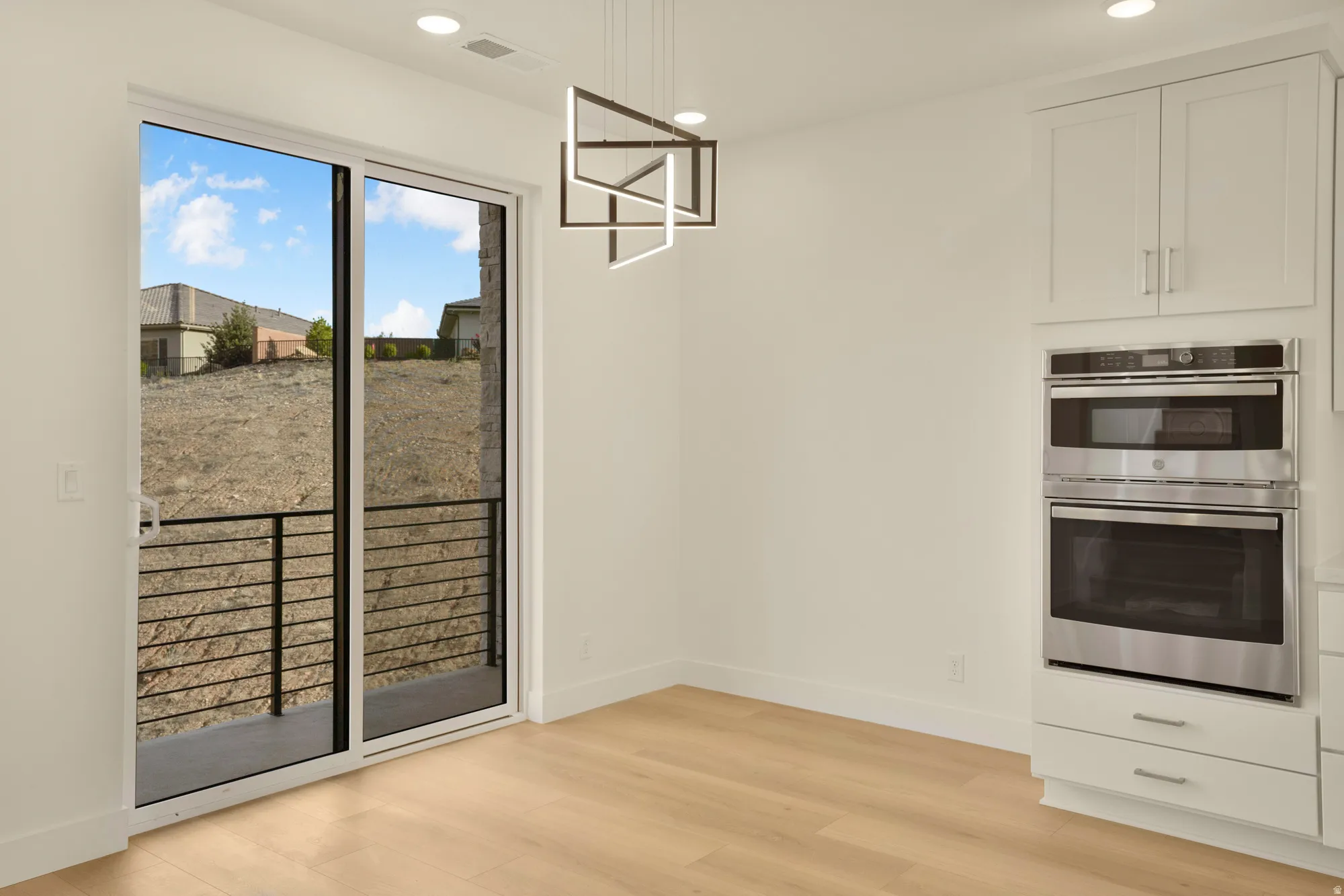Sliding glass door opening to an outdoor area with horizontal metal railings