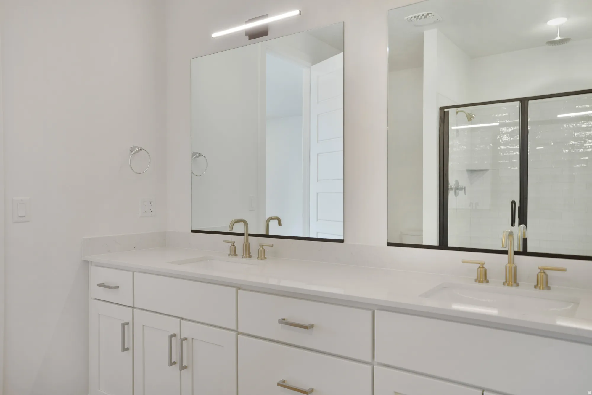 Dual vanity with white cabinetry, light-toned countertops, and two rectangular undermount sinks