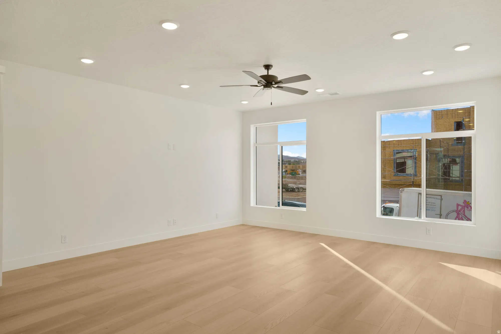 Expansive interior space featuring light wood-finish flooring and recessed lighting