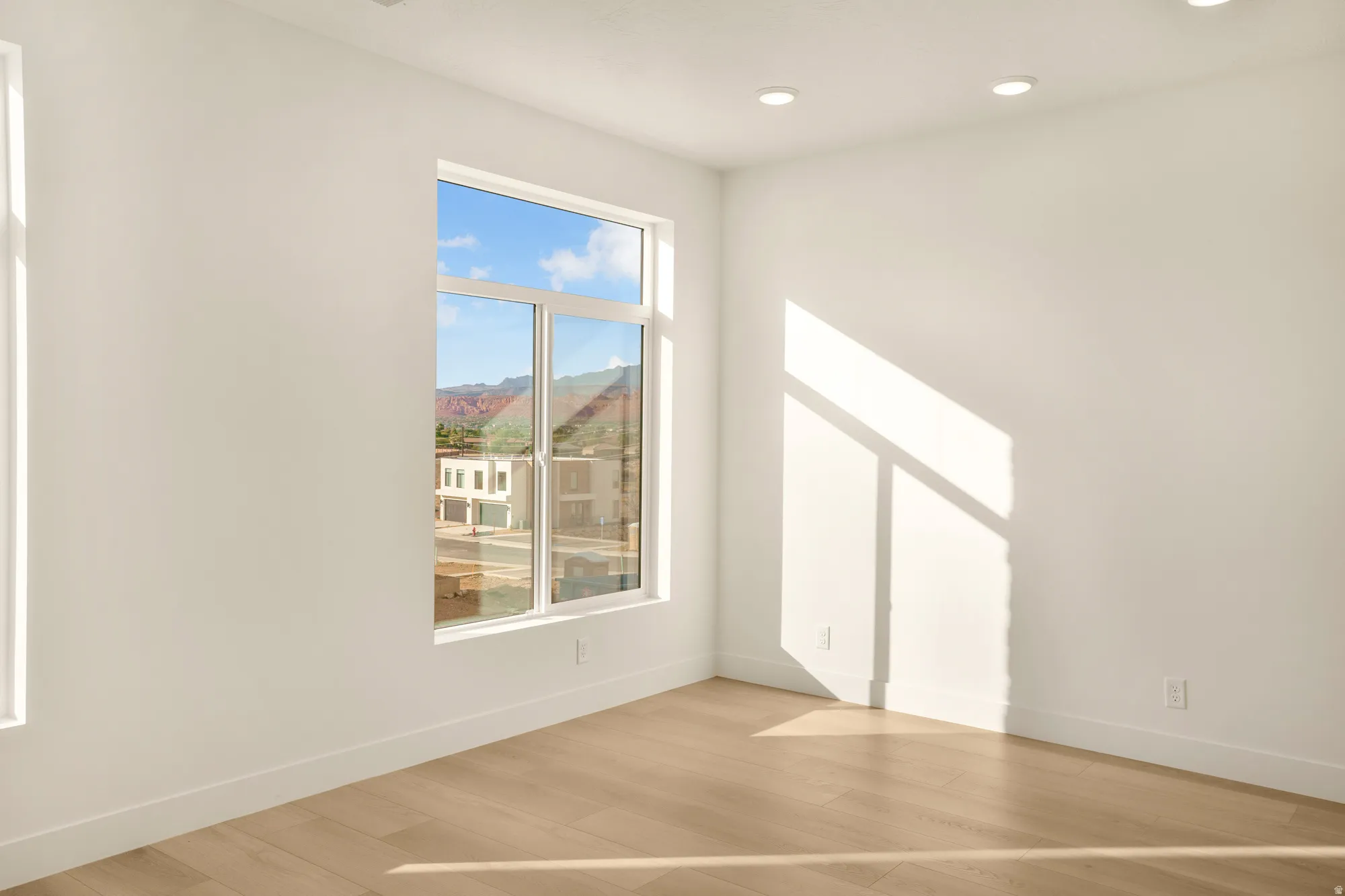 Room featuring light wood-finish flooring, white baseboards, and recessed ceiling lighting