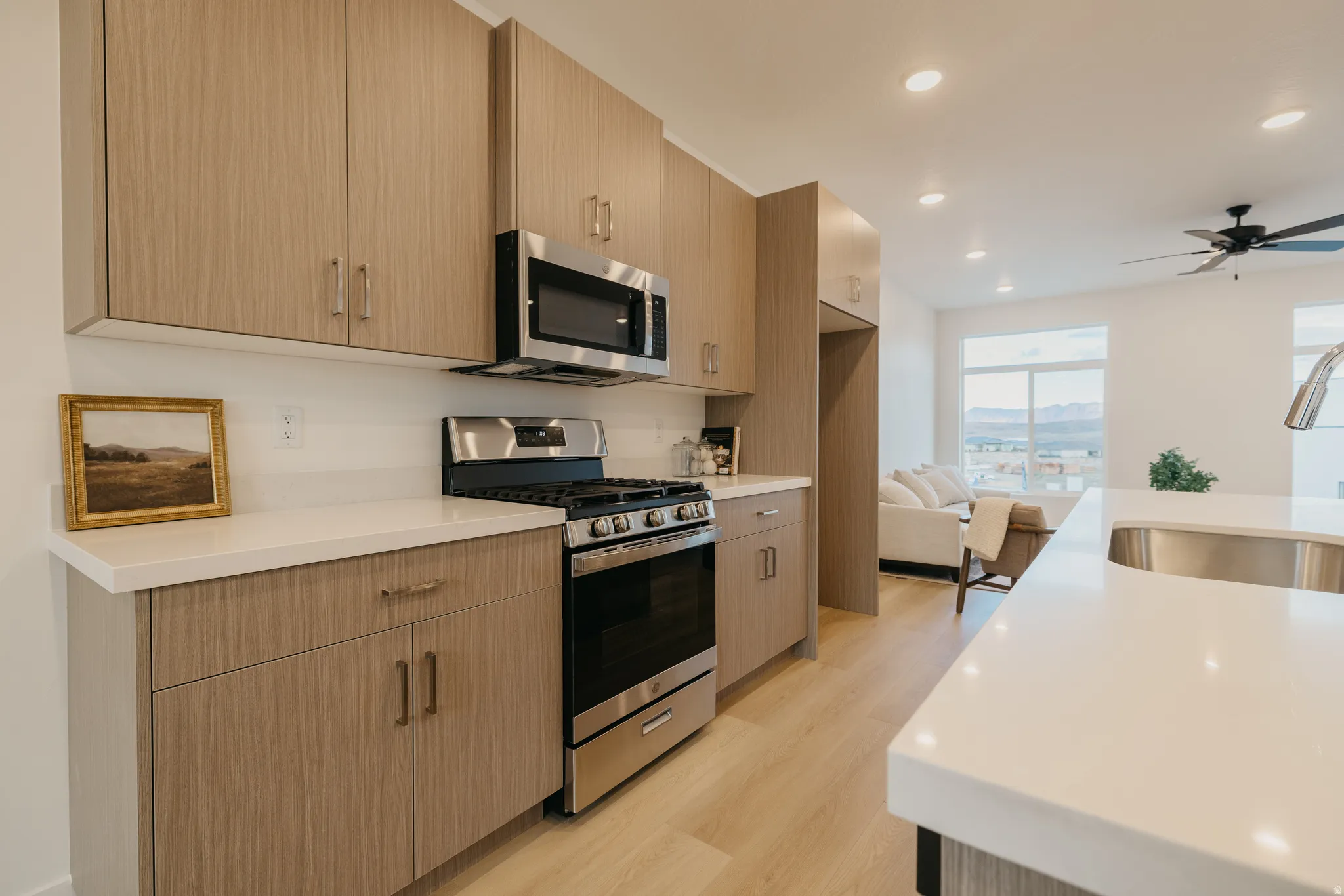 Kitchen featuring stainless steel appliances, light wood-type flooring, recessed lighting, modern cabinets, and light stone countertops