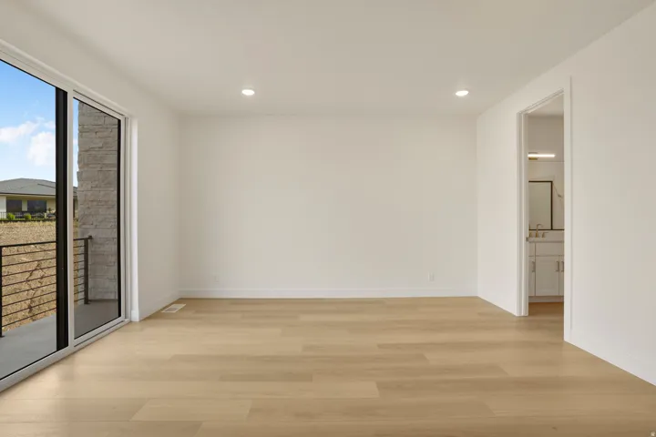 Spacious interior featuring light wood-finish flooring, recessed lighting, and white baseboards