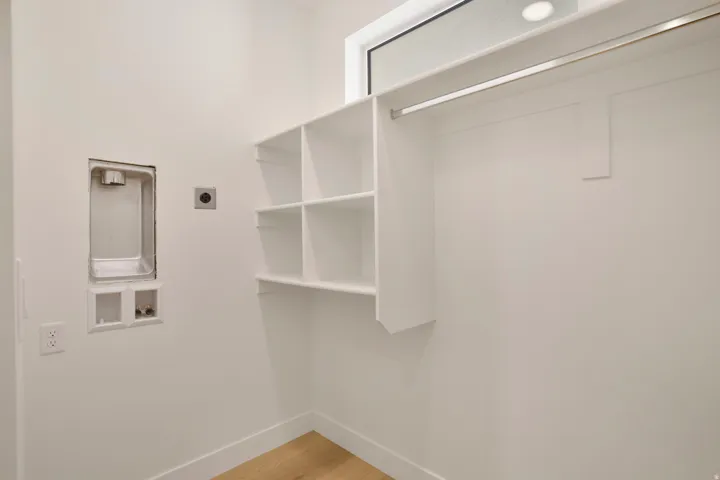 Dedicated laundry area featuring a washer hookup, dryer vent, and light wood-finish flooring