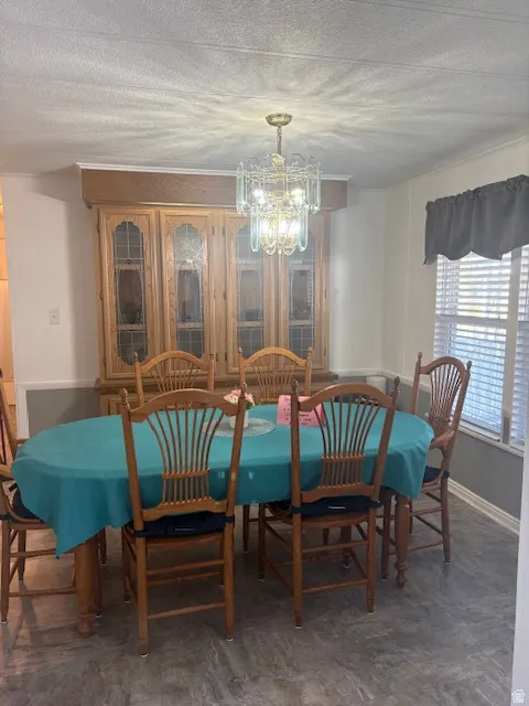 Dining area featuring a chandelier and a textured ceiling