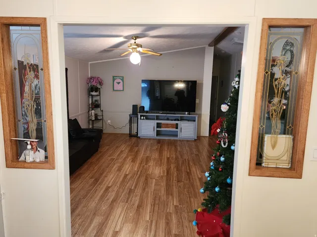 Living area featuring wood finished floors, vaulted ceiling, and ceiling fan
