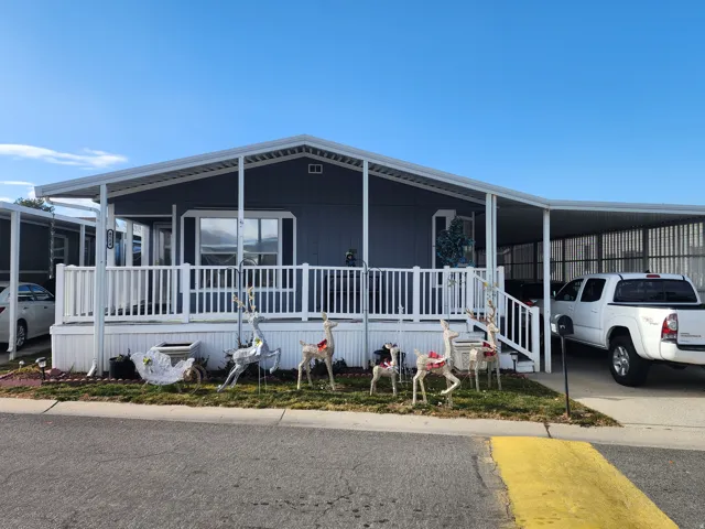 Manufactured / mobile home featuring a large porch and a carport