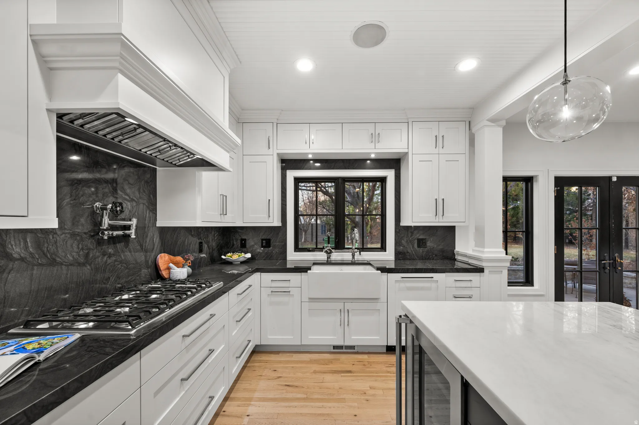 Kitchen featuring white cabinetry, tasteful backsplash, recessed lighting, dark stone countertops, and light wood-style floors