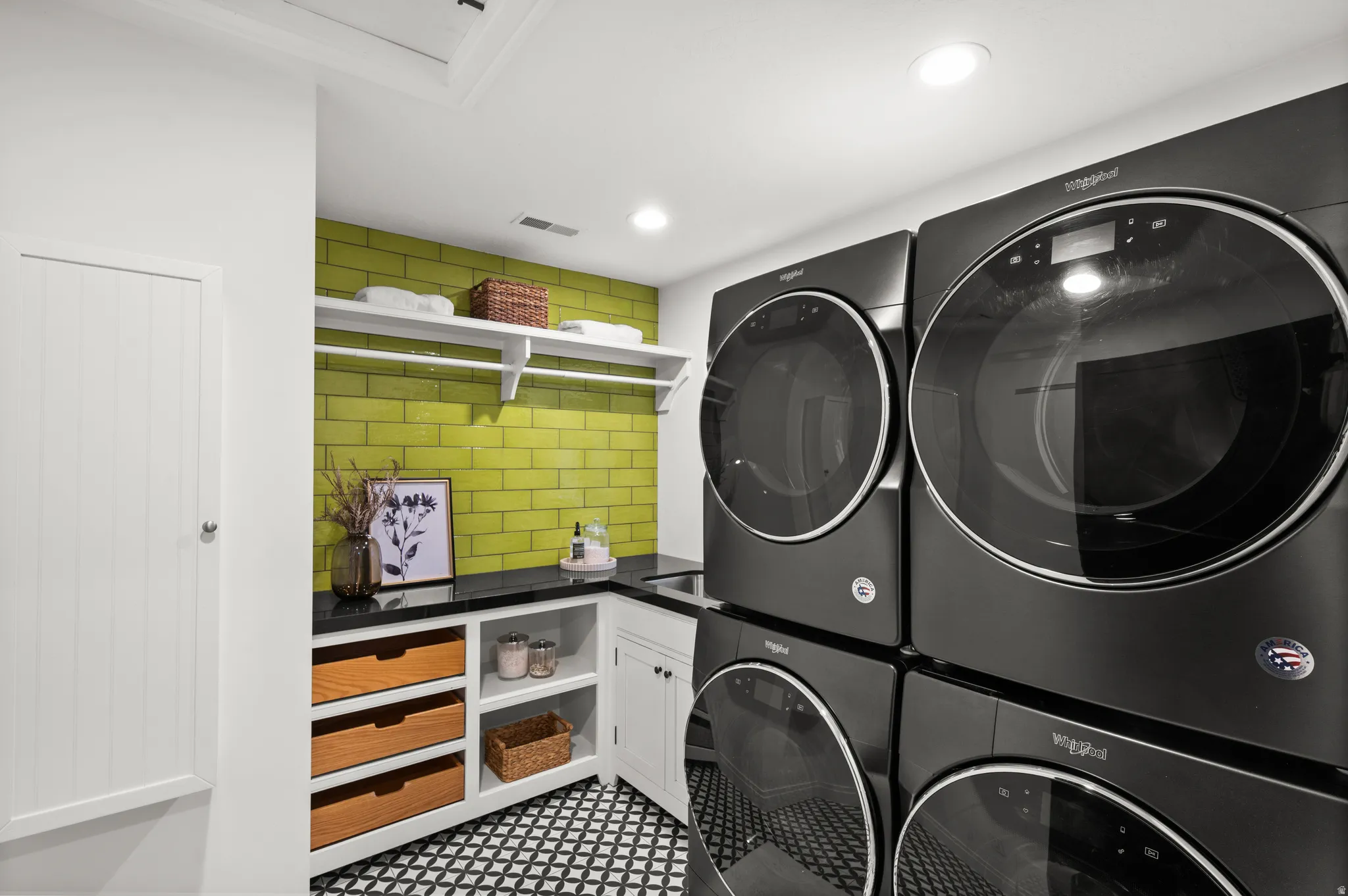 Washroom with stacked washer and clothes dryer and recessed lighting