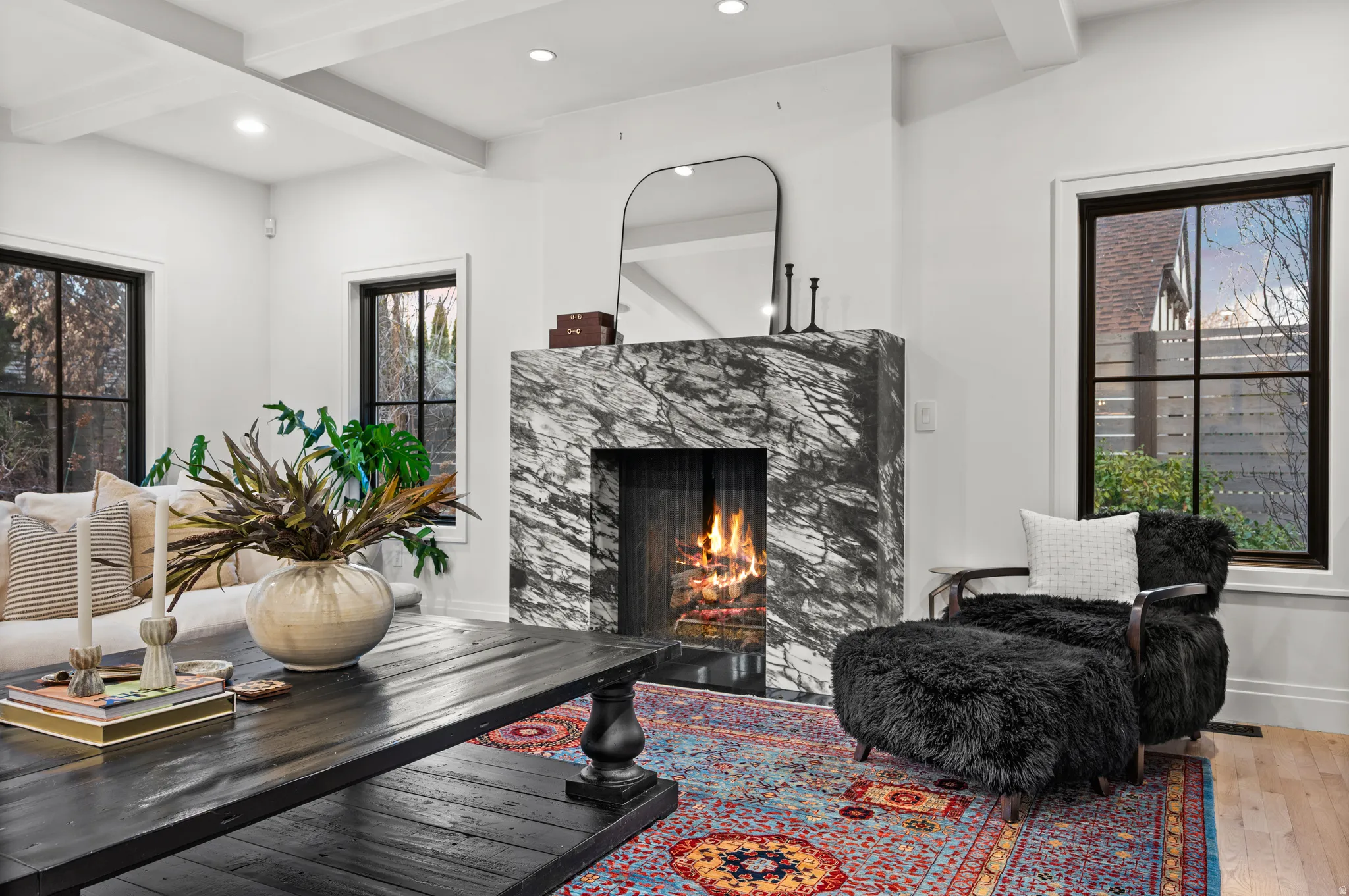 Sitting room featuring beam ceiling, recessed lighting, a lit fireplace, and hardwood / wood-style flooring