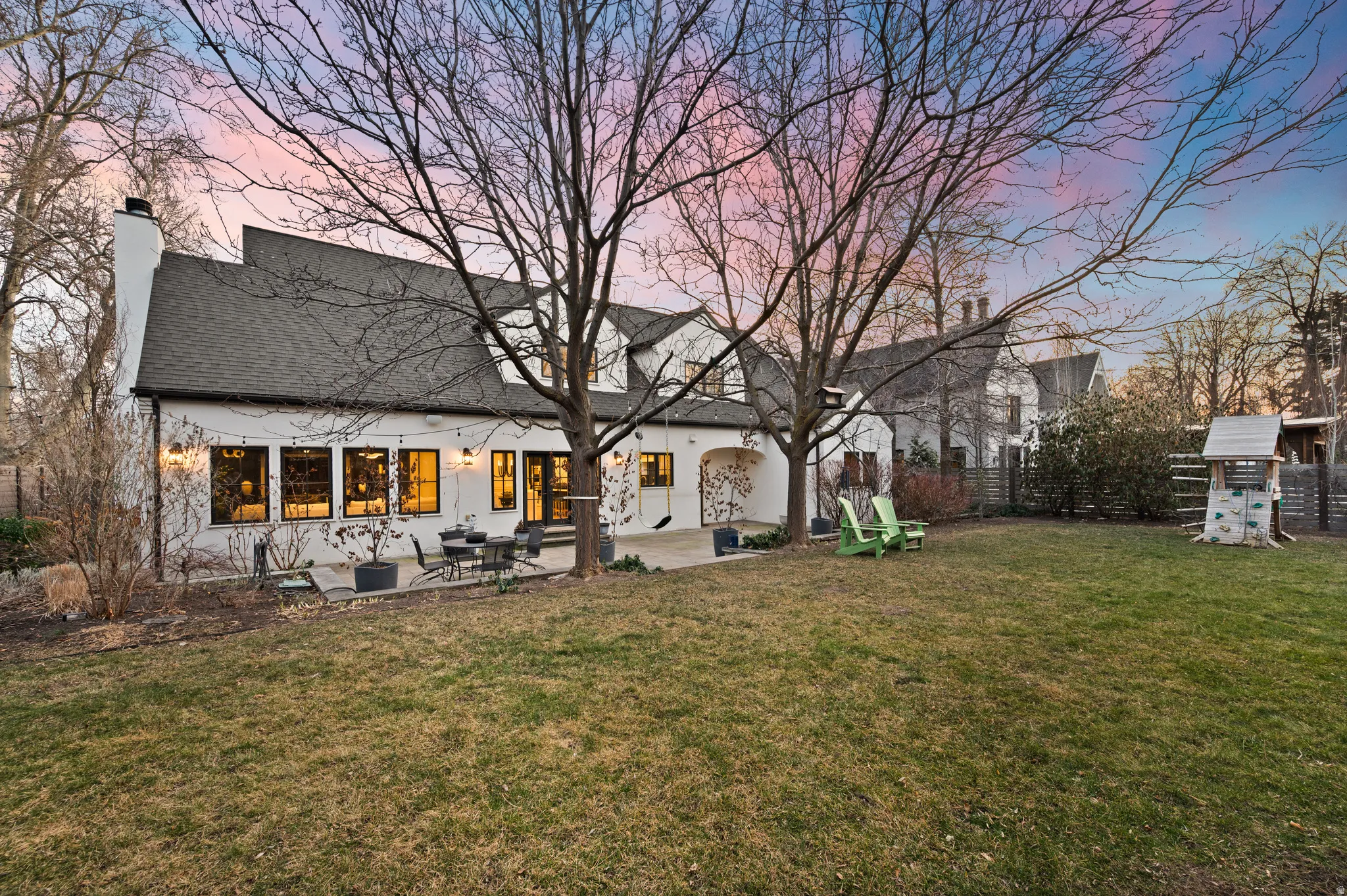 Back of property with a patio area, a chimney, roof with shingles, and a playground