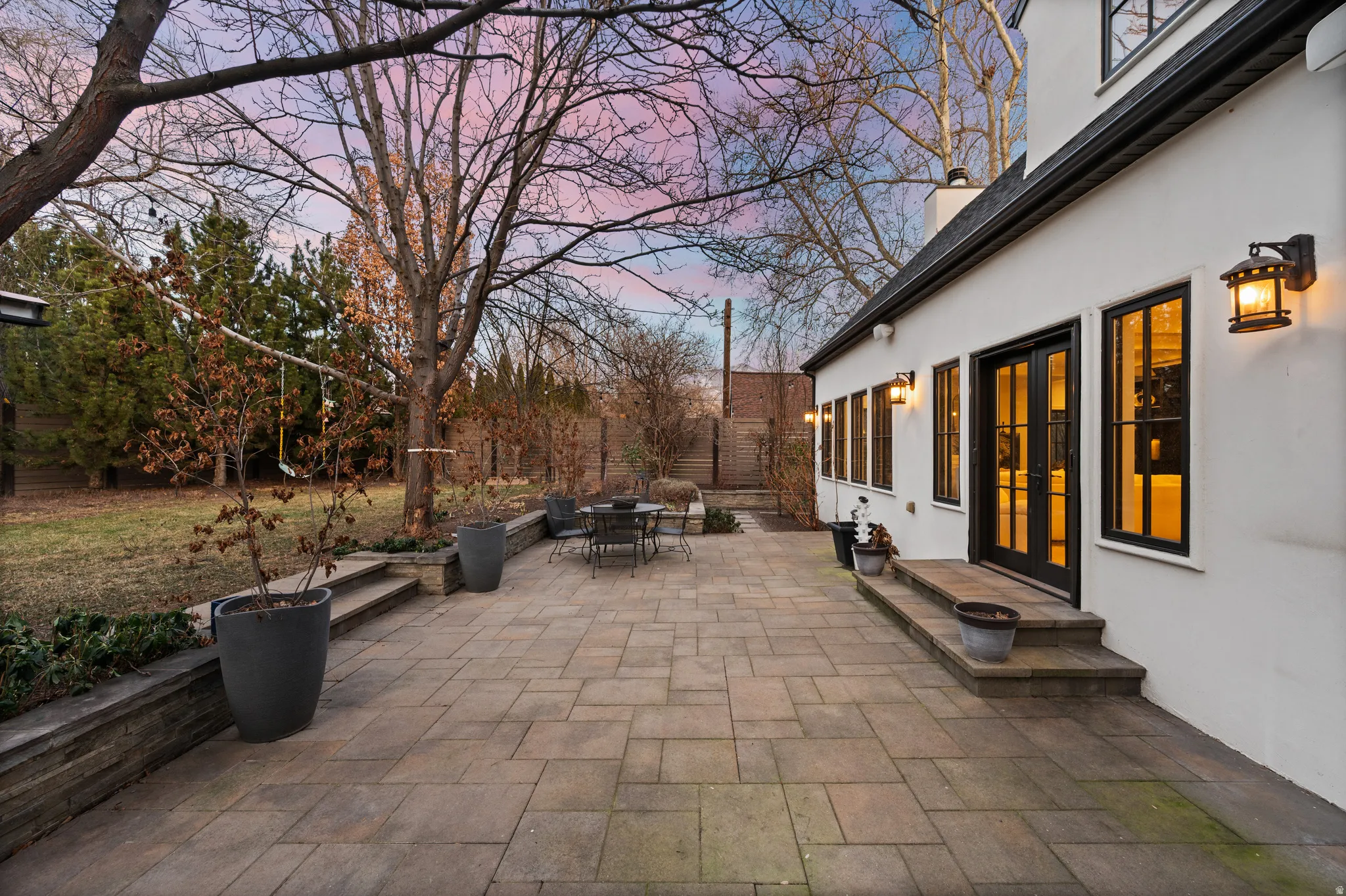 Patio terrace at dusk with outdoor dining area, a patio, and french doors