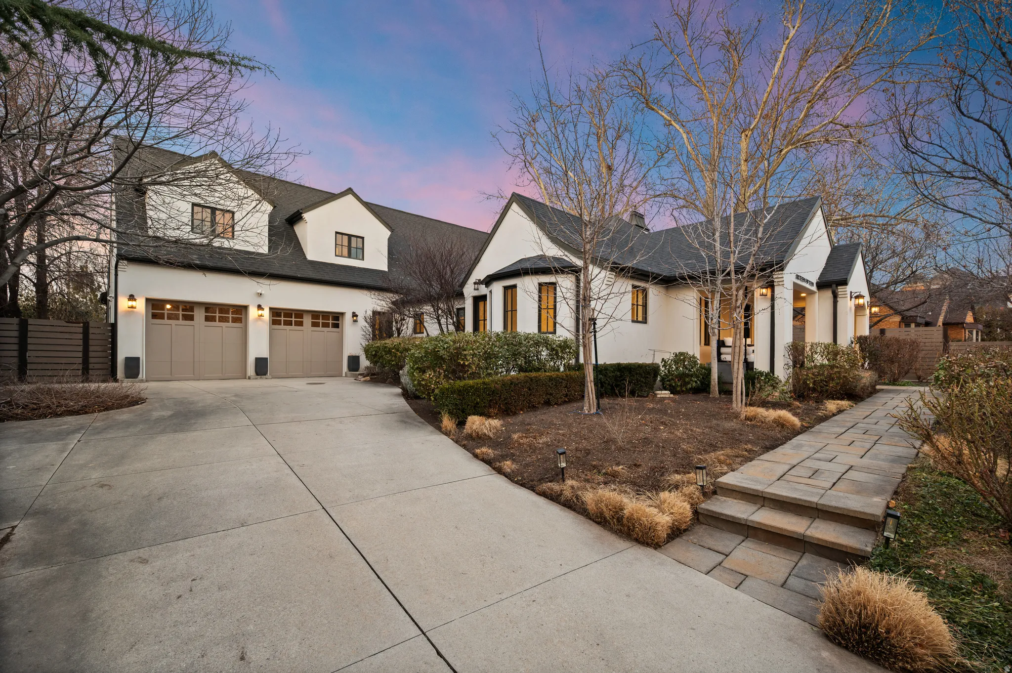 Modern farmhouse style home with driveway, a garage, stucco siding, and a shingled roof