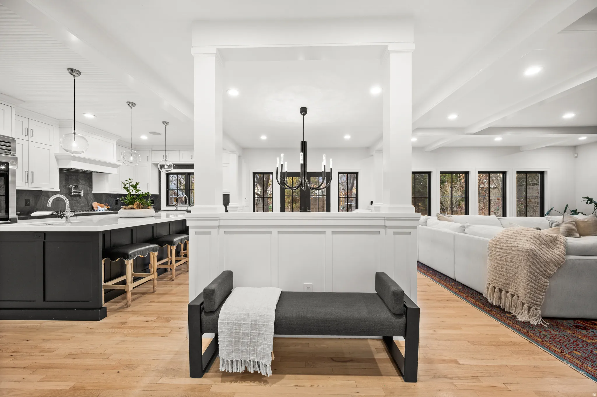 Living room with a chandelier, light wood-style flooring, recessed lighting, and beamed ceiling