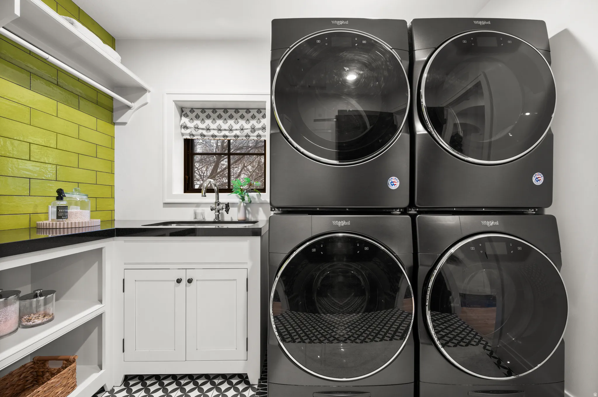 Laundry room with stacked washer and clothes dryer and cabinet space