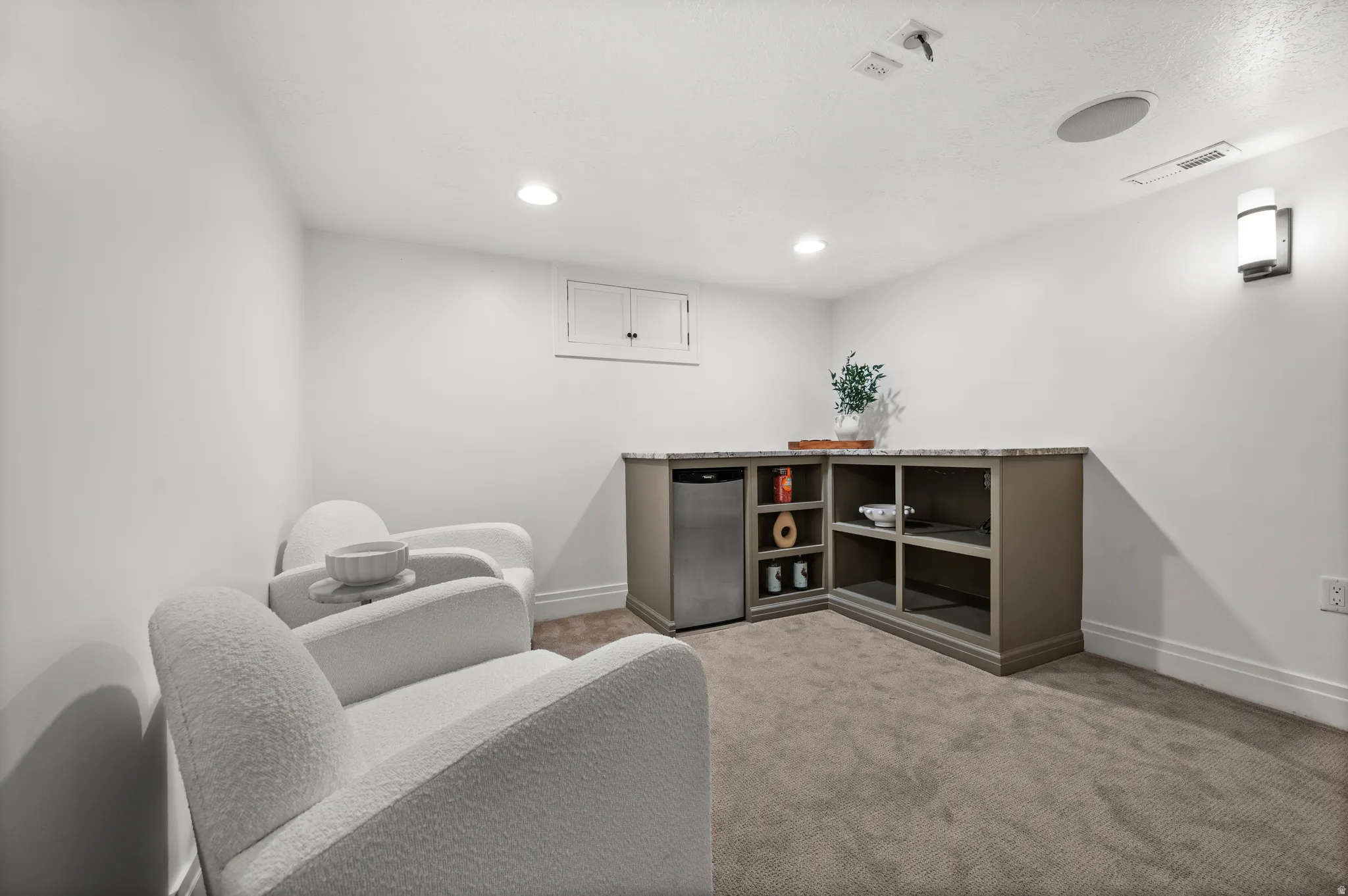 Sitting room with light carpet and recessed lighting