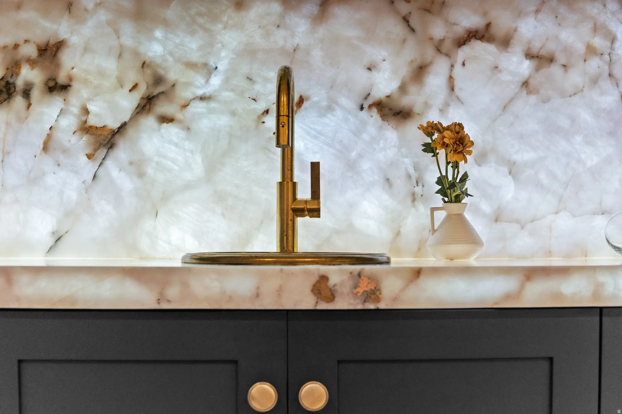 Kitchen view of a sink and gray cabinetry
