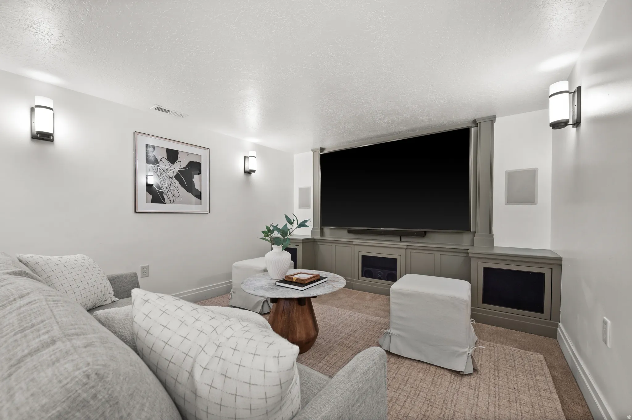 Home theater featuring carpet floors and a textured ceiling