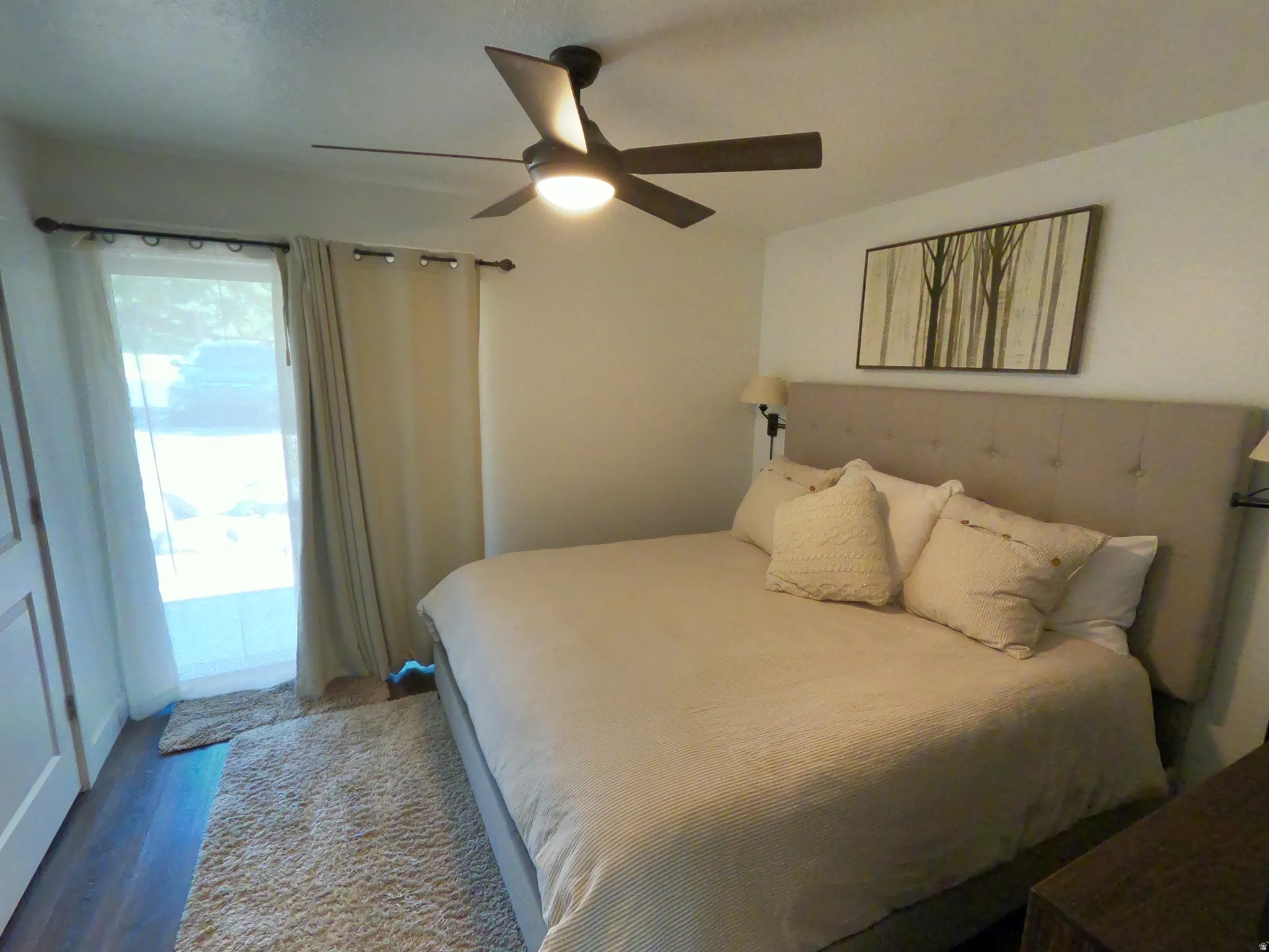 Bedroom featuring ceiling fan, wood finished floors, and access to outside