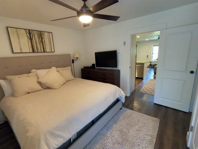 Bedroom with dark wood-style floors and a ceiling fan