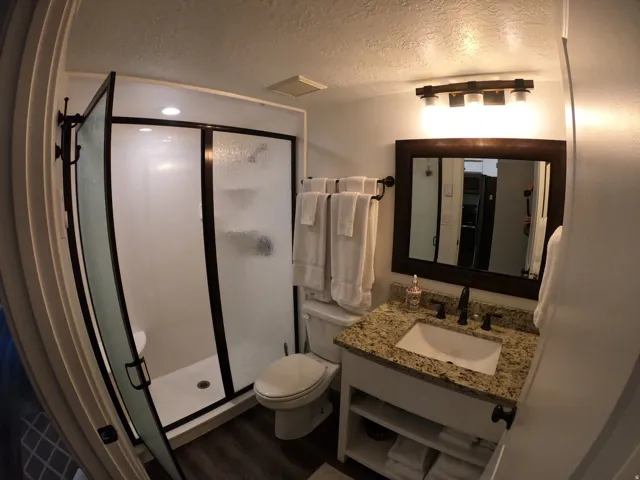 Bathroom featuring a shower stall, a textured ceiling, vanity, and dark wood finished floors