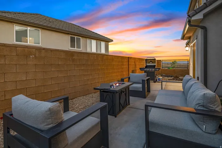Fully Fenced Backyard with an Outdoor Living Space with a Fire Pit, and Grill
