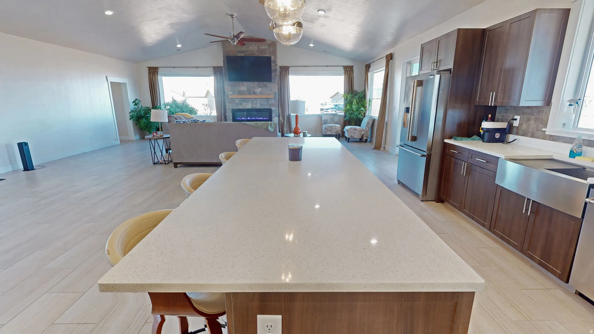 Kitchen featuring a breakfast bar area, open floor plan, plenty of natural light, and vaulted ceiling