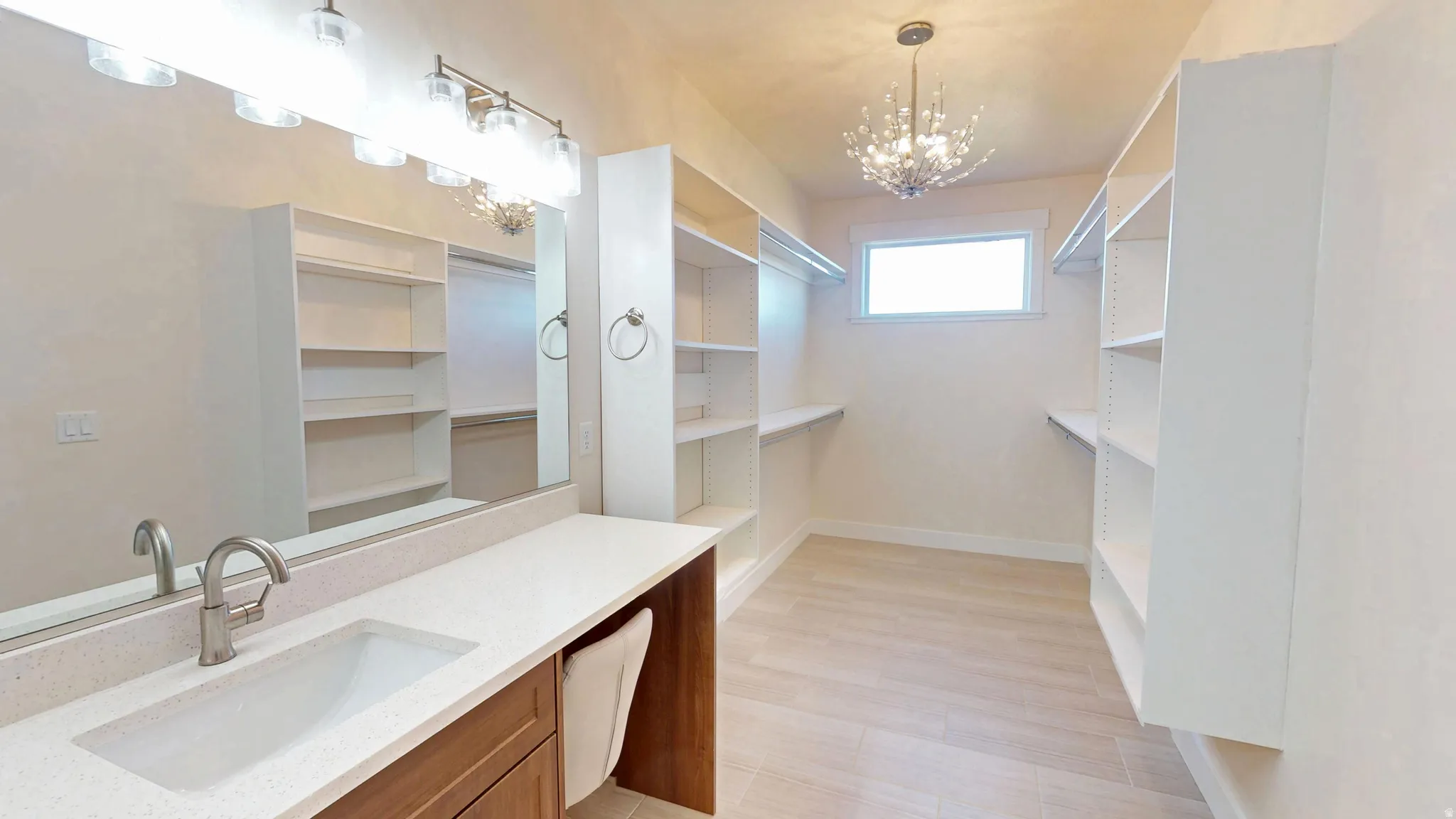 Spacious closet featuring a sink and a chandelier