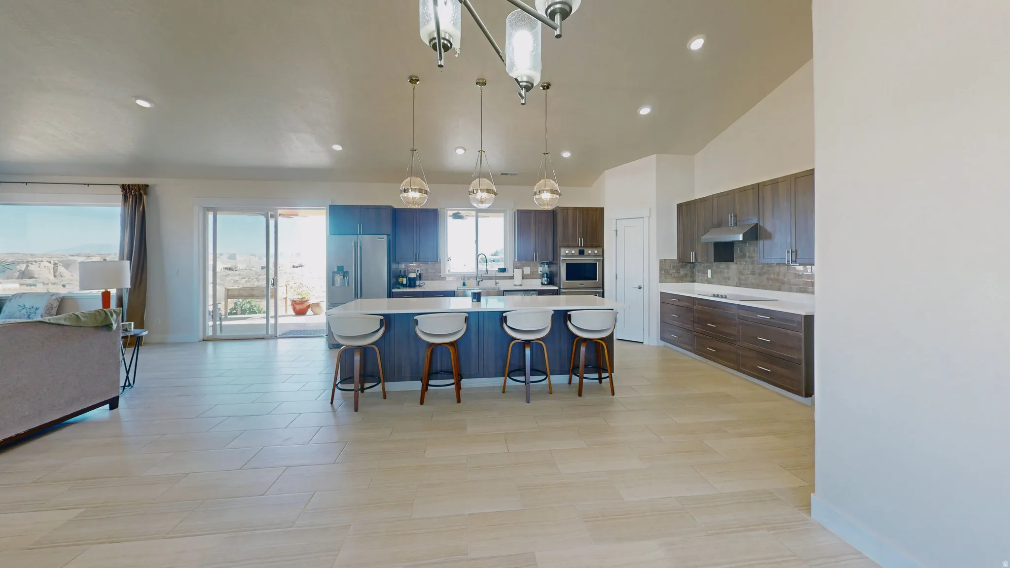 Kitchen with a breakfast bar, a large island, hanging light fixtures, decorative backsplash, and open floor plan