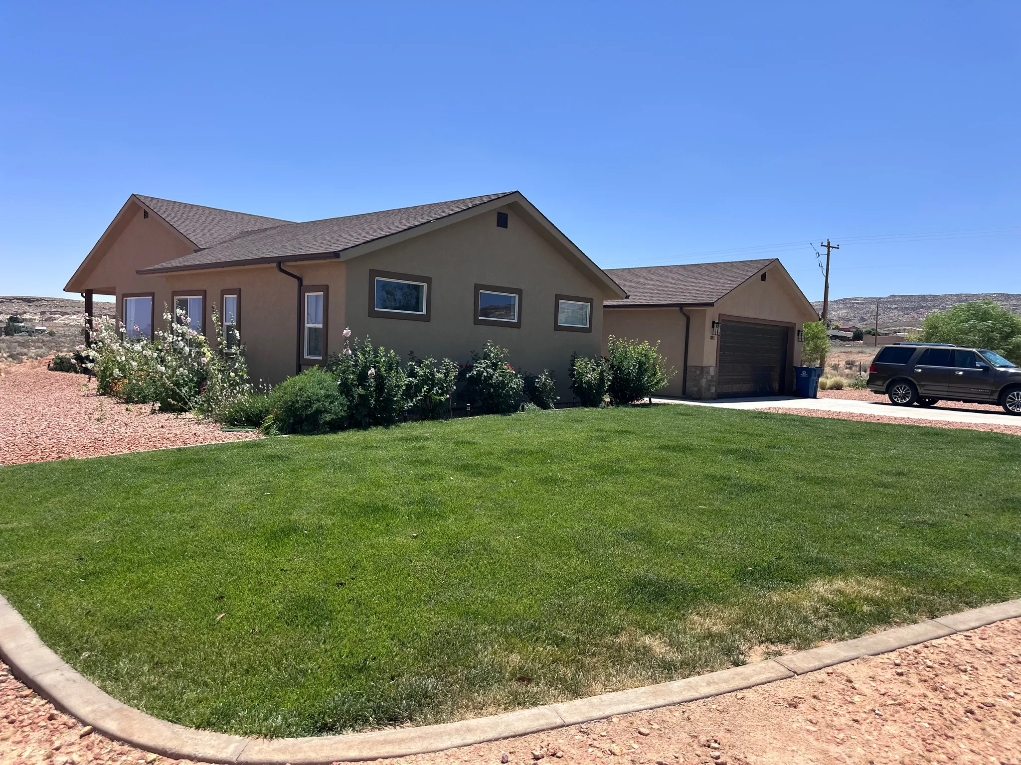Ranch-style house featuring stucco siding, driveway, and a front yard