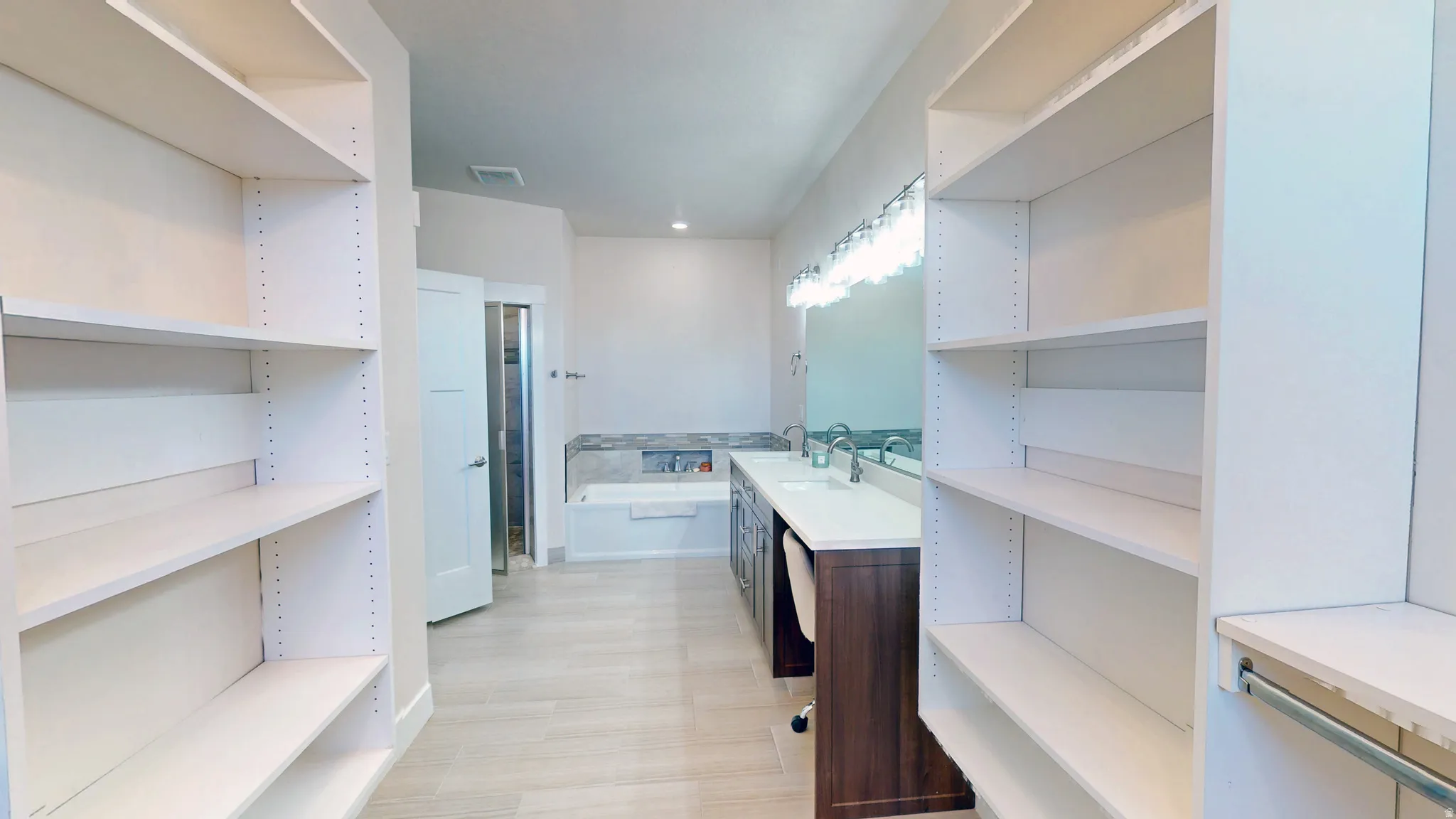 Bathroom with vanity, a bath, and a closet