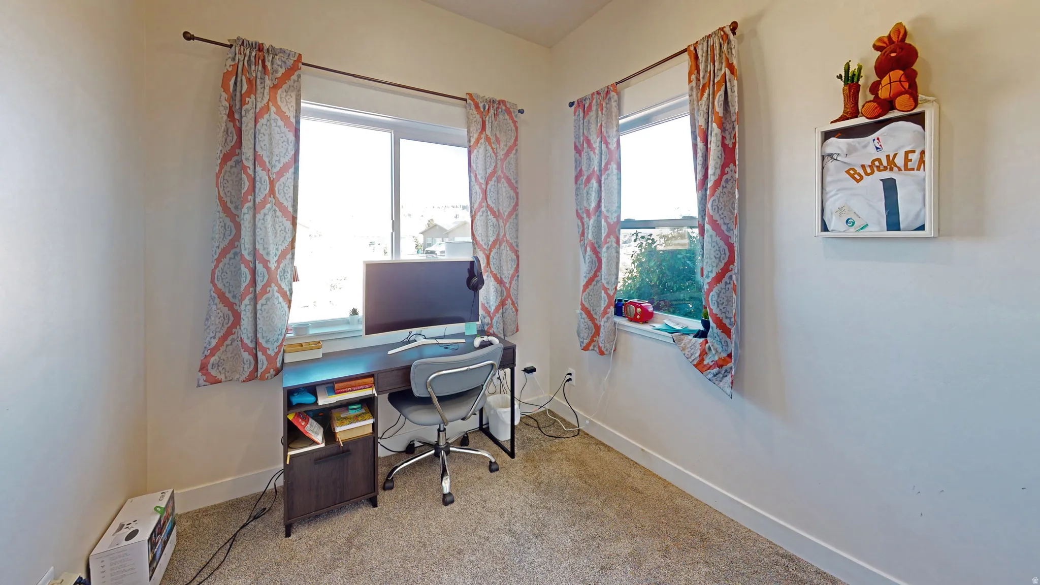 Office with light colored carpet and plenty of natural light