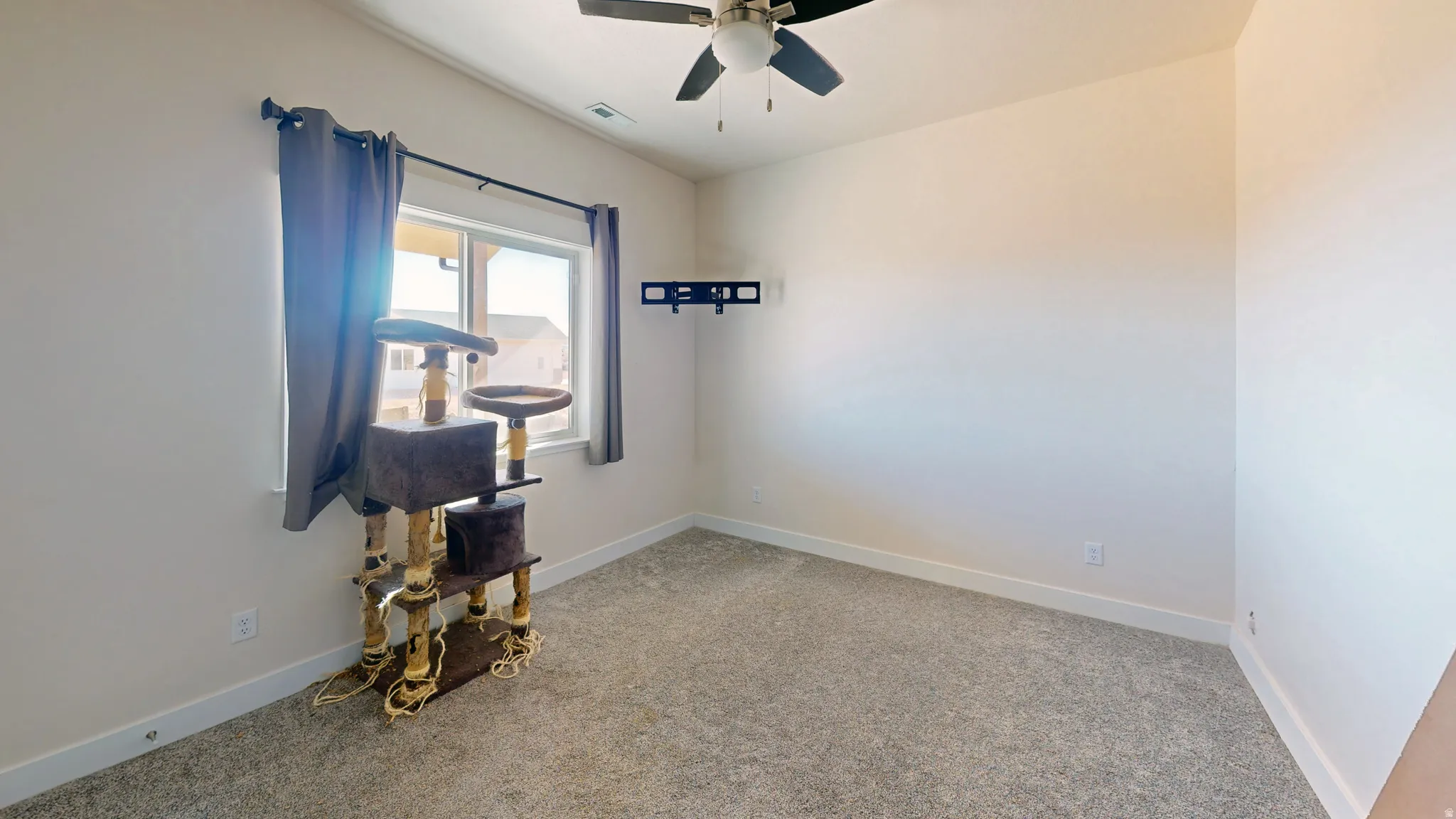 Unfurnished room with light colored carpet and a ceiling fan