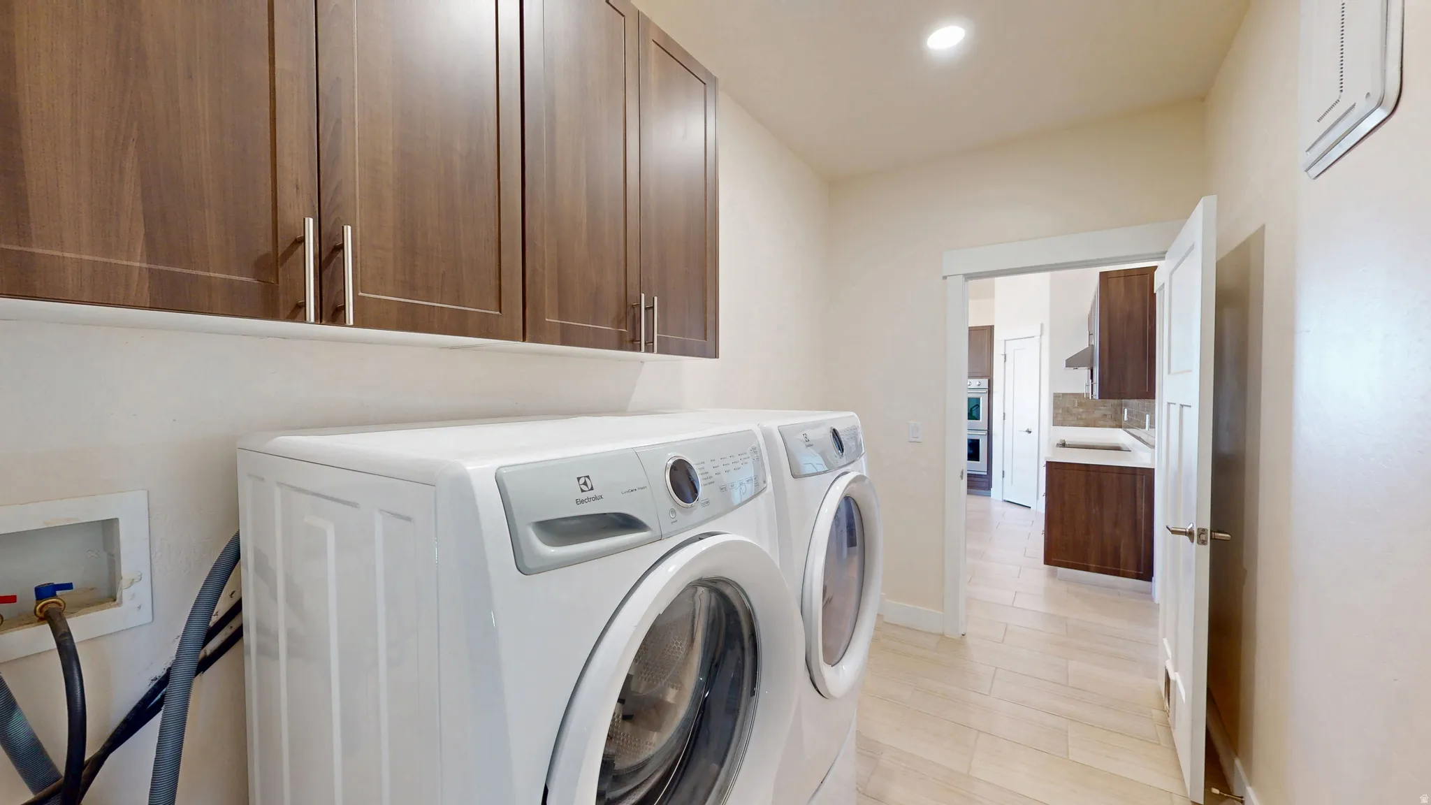 Laundry room featuring cabinet space, recessed lighting, and washer and dryer