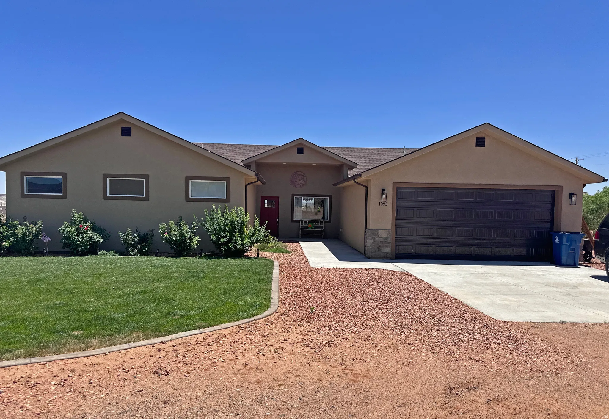 Single story home with driveway, a front lawn, stucco siding, and an attached garage