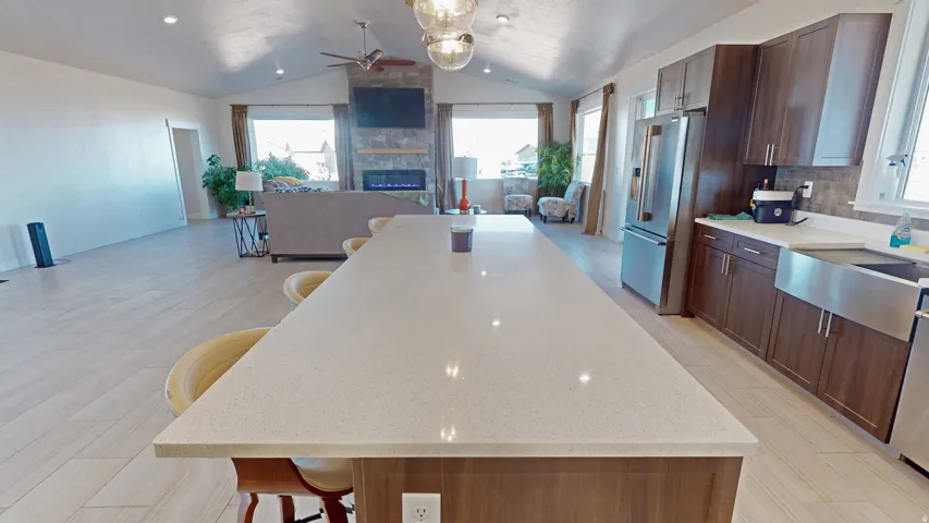 Kitchen featuring a breakfast bar area, open floor plan, plenty of natural light, and vaulted ceiling