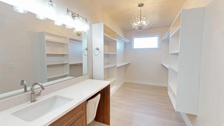 Spacious closet featuring a sink and a chandelier