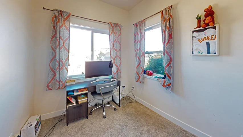 Office with light colored carpet and plenty of natural light
