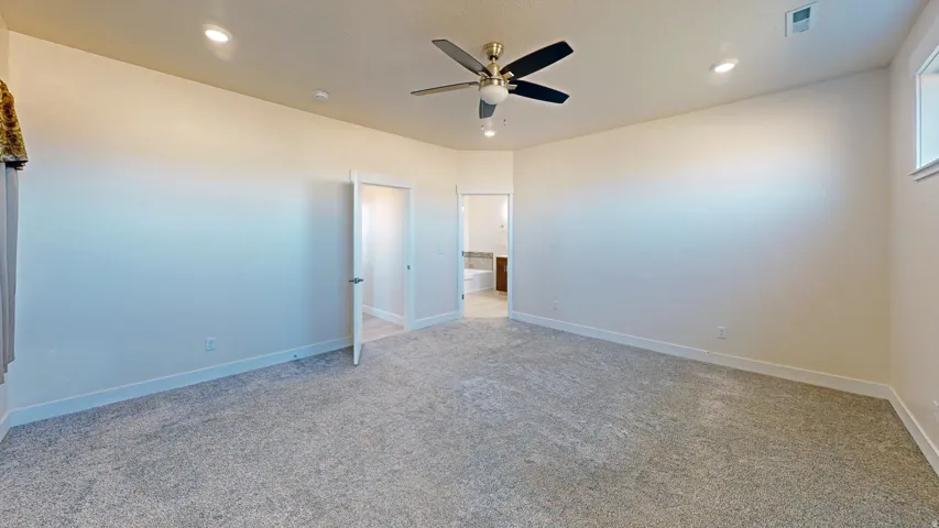 Unfurnished bedroom featuring a ceiling fan, carpet flooring, recessed lighting, and connected bathroom