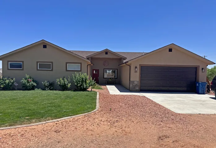 Single story home with driveway, a front lawn, stucco siding, and an attached garage