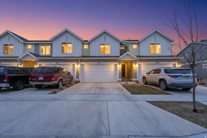 Traditional home featuring board and batten siding, concrete driveway, and a garage
