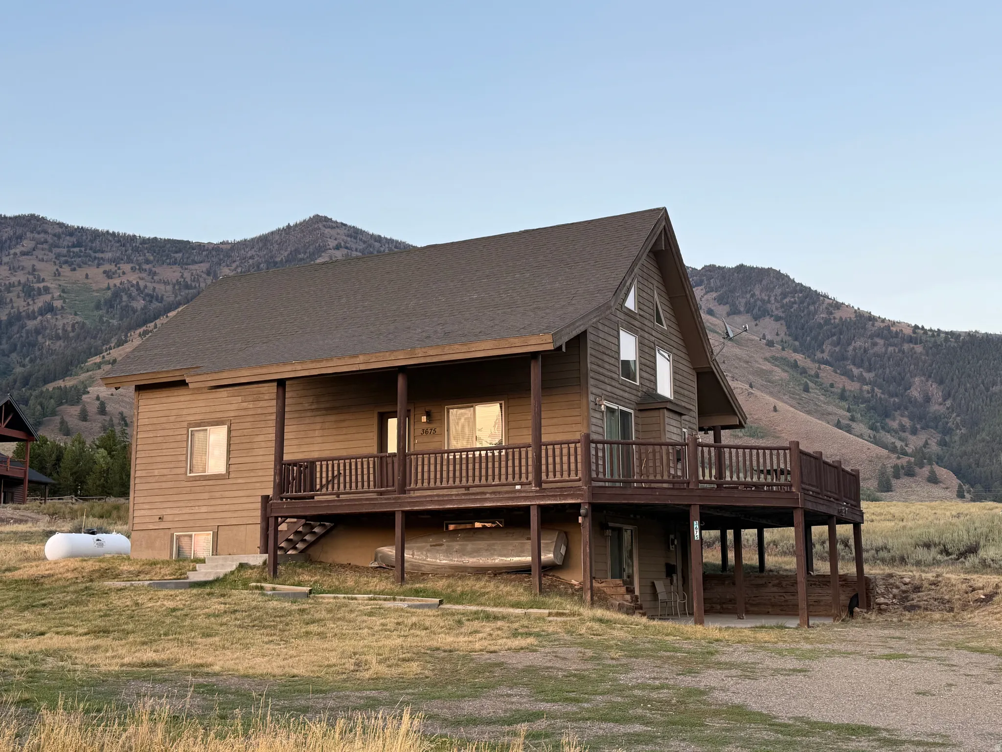 View of front of home featuring roof with shingles and a deck with mountain view