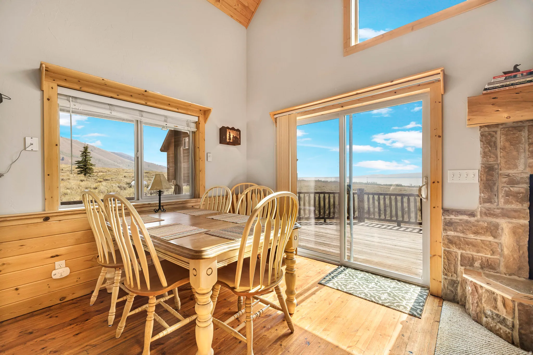Dining area featuring hardwood / wood-style flooring, a towering ceiling, and a mountain view