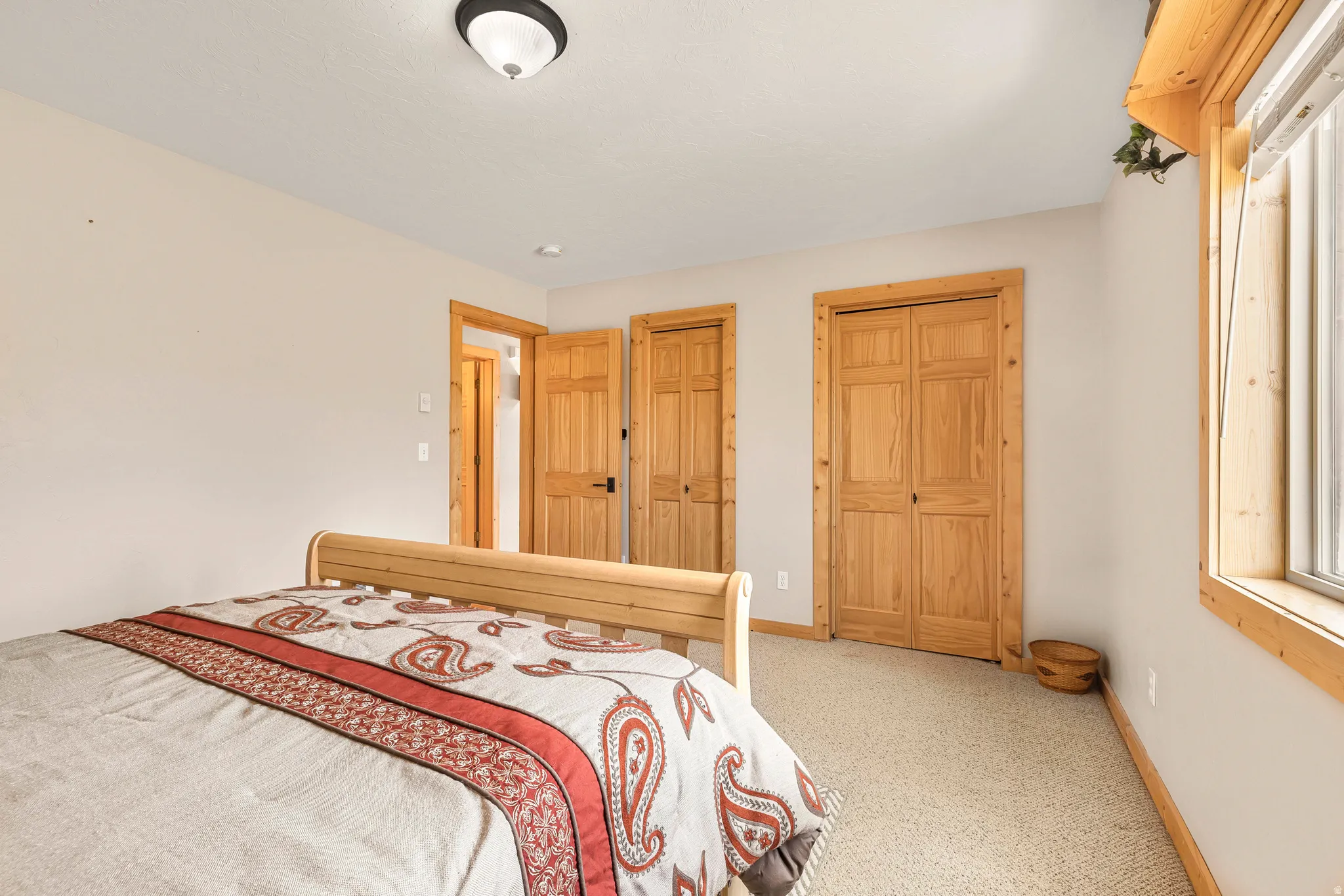 Carpeted bedroom featuring two closets and baseboards